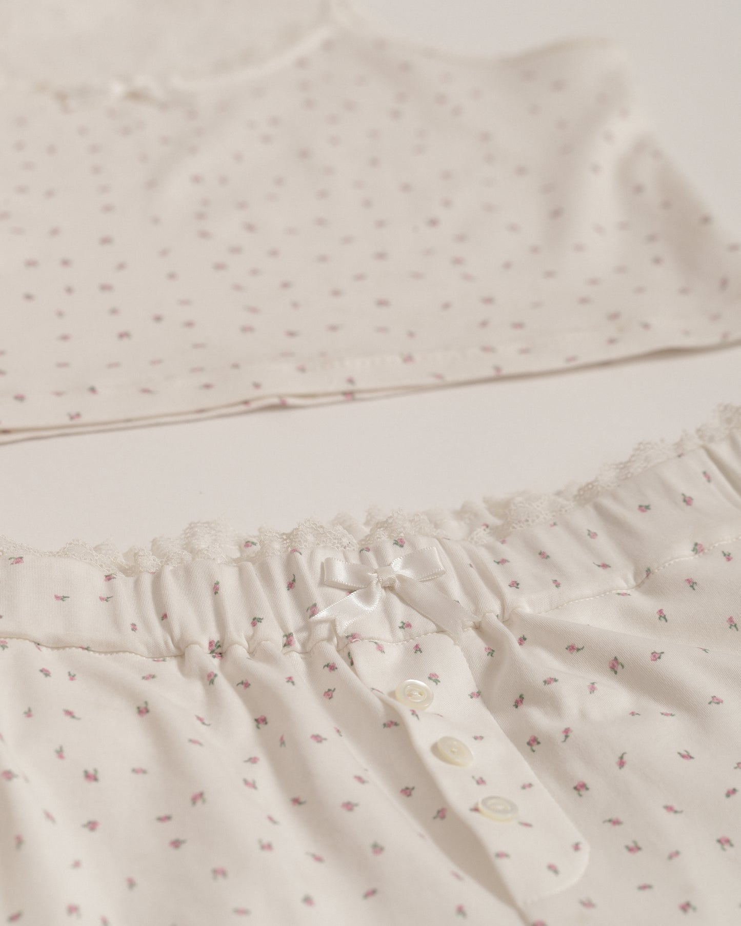 detail close up shot of dainty floral print pajamas with lace trim and bow detail