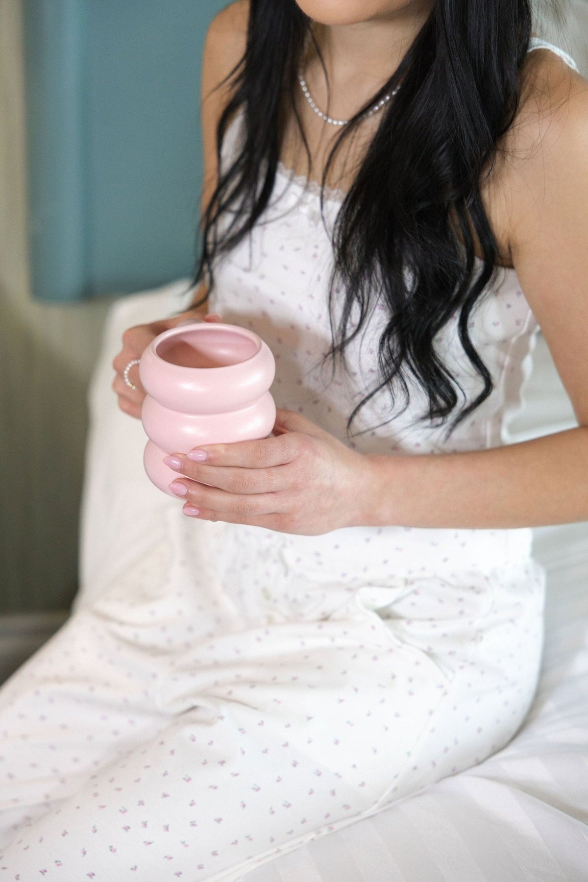 Close detail of the hand drawn Garden floral print on The Love Letter cotton pajamas, holding a pink ceramic mug