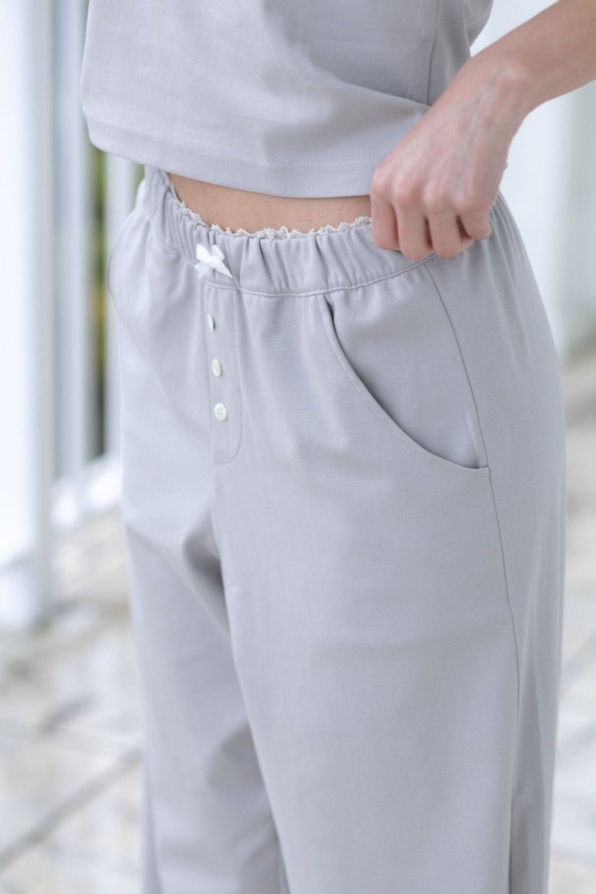 Side detail of The Moonmilk cotton pajama pants in Stone, showing the curved pocket opening