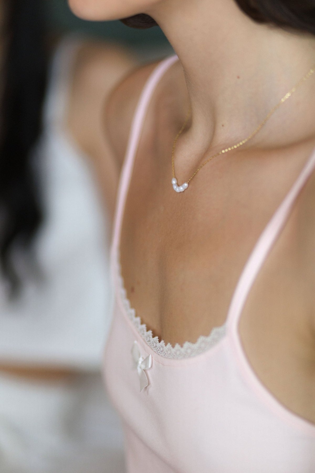Close view of the scoop neckline on The Raspberry cotton pajama top, with lace trim and a small white bow