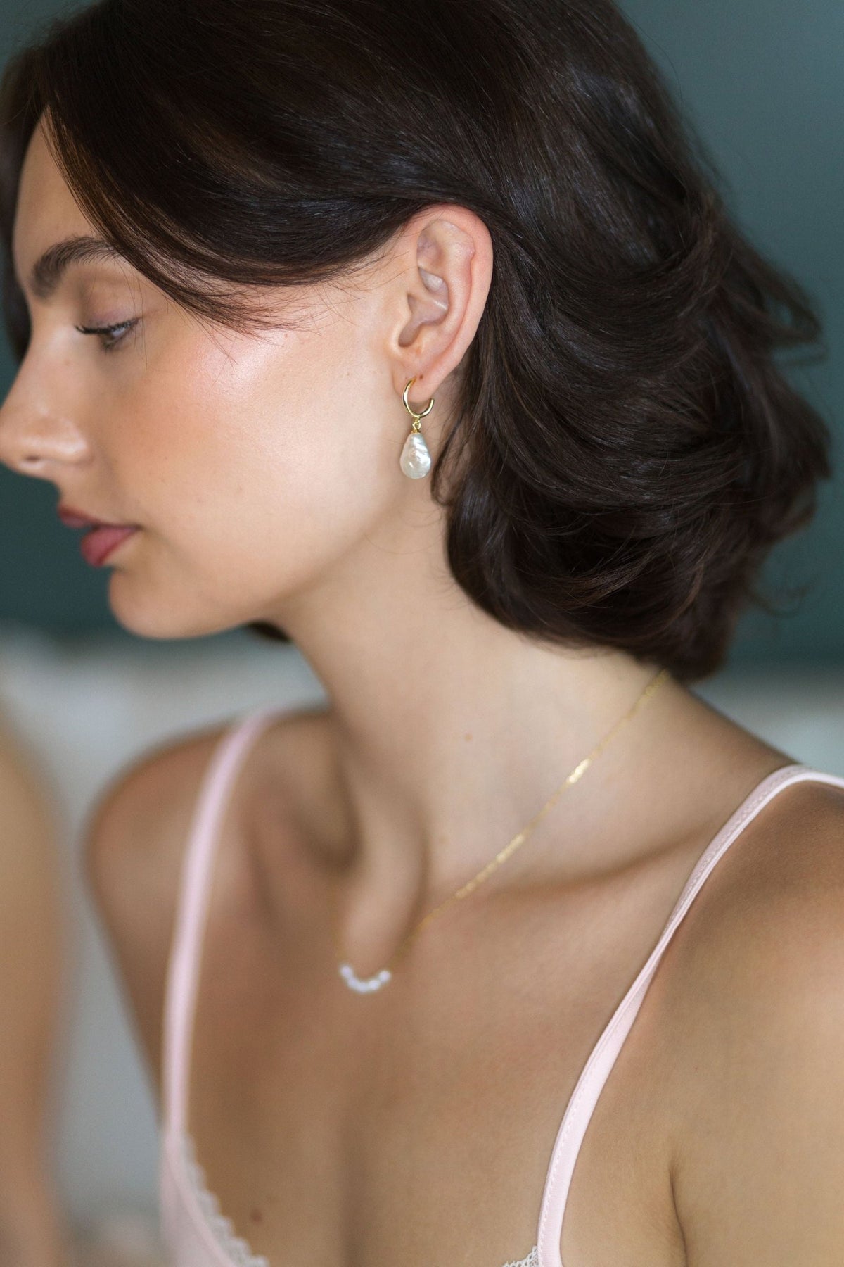 Side profile showing the thin adjustable strap of The Raspberry cotton pajama top in blush pink